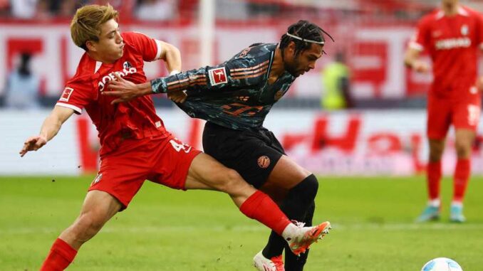sc-freiburg-s-ritsu-doan-in-action-with-bayern-munich-s-serge-gnabry